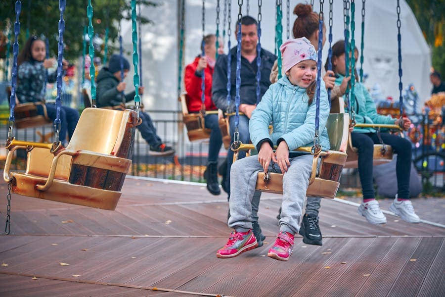 Kids smiling on a swing ride at an amusement park