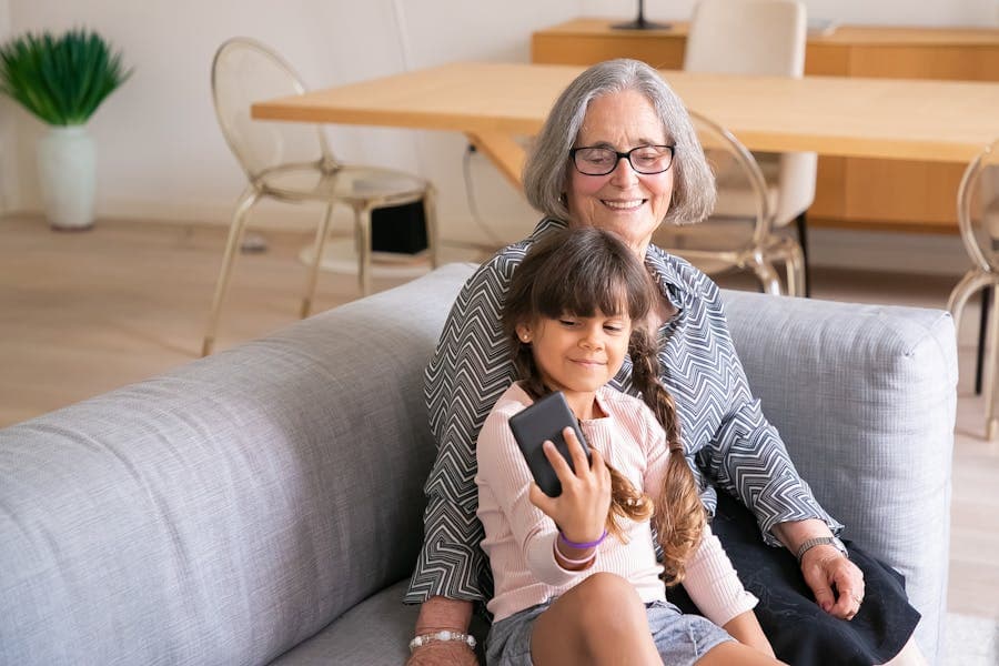 A grandparent smiling at a phone