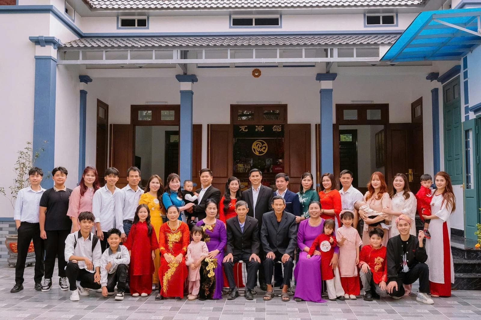 A big extended family smiling together outdoors